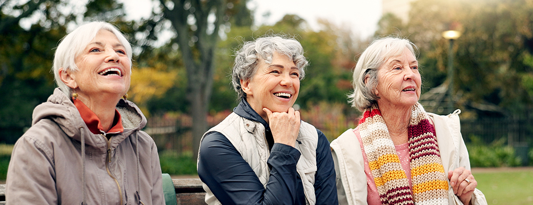 Image of three senior women sitting outside and chatting